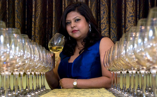 Sonal holds a glass of white wine 