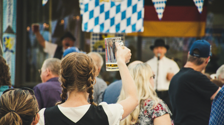 Woman raising beer glass in crowd