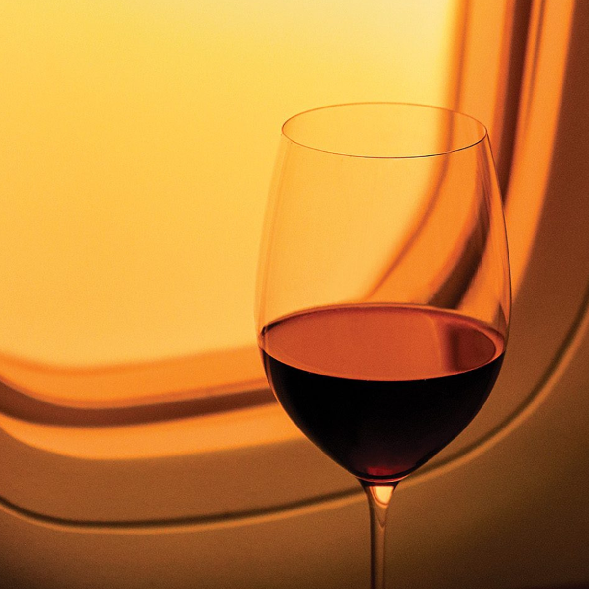 Glass of wine by airplane window