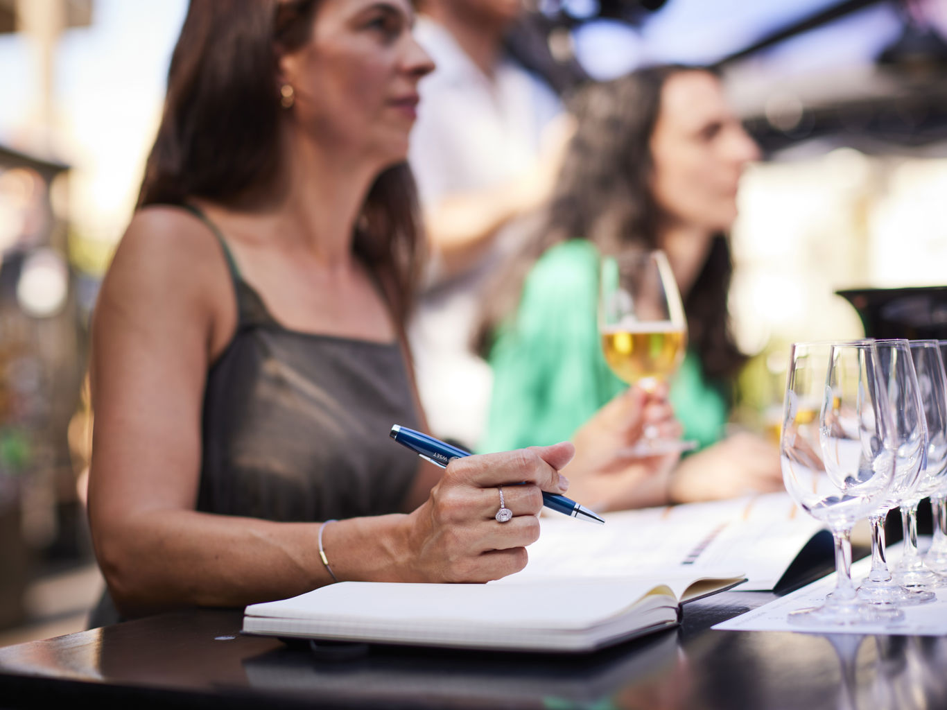 Woman with open textbook, pen and glass of beer