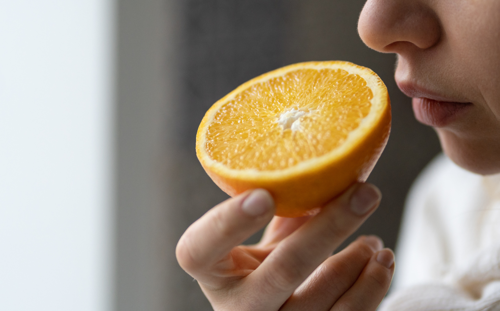 A person sniffs half an orange