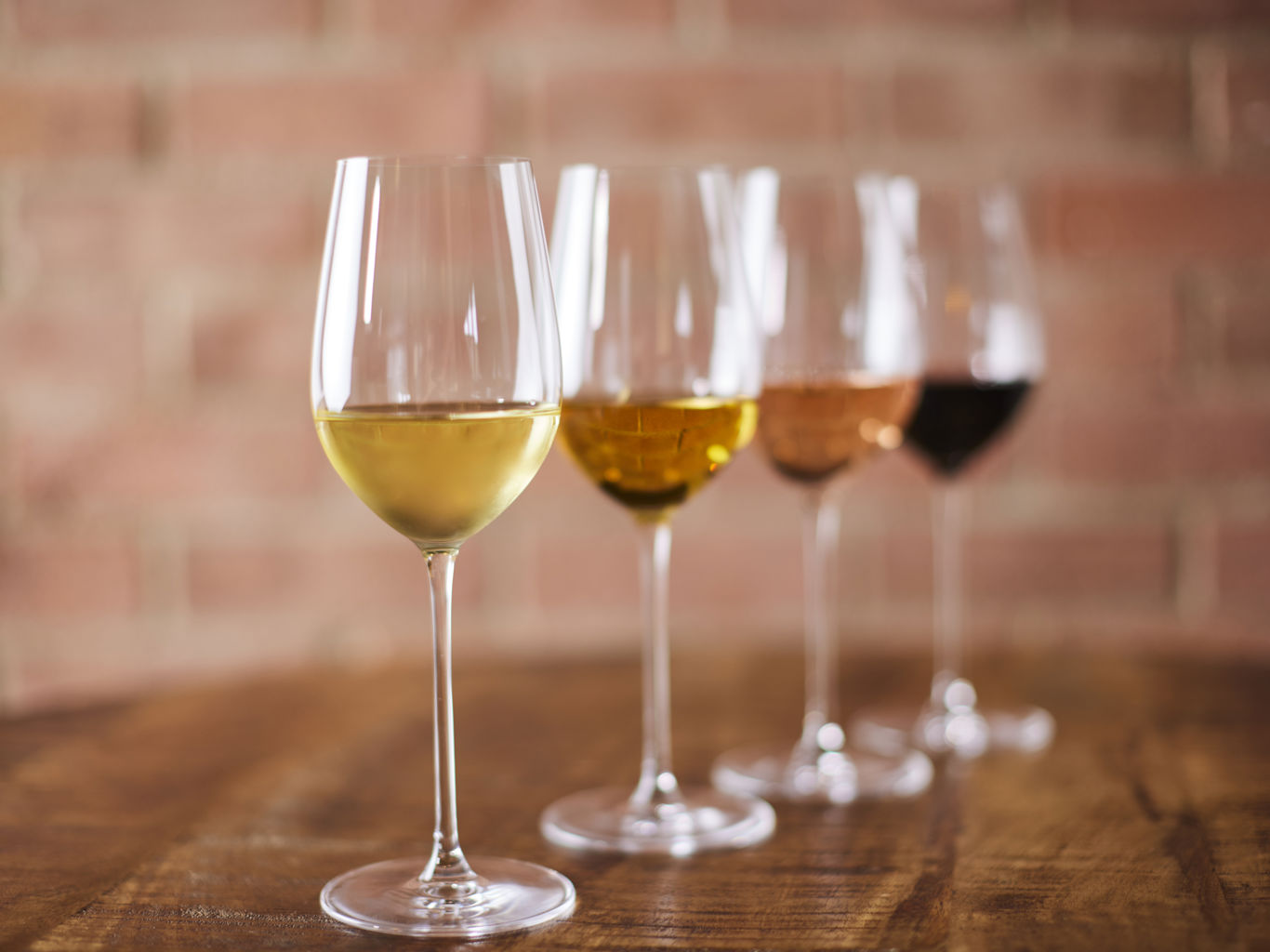 Four glasses with different types of wine in them