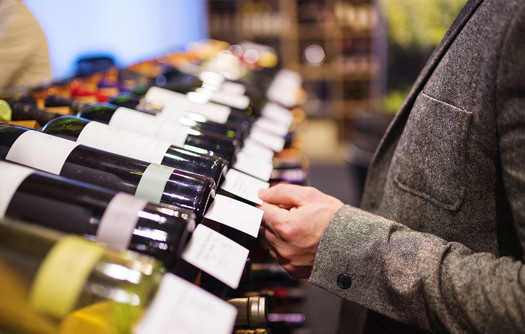 Person reading wine labels
